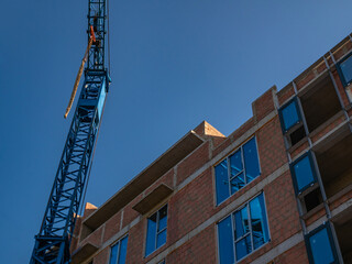 Fototapeta na wymiar Construction crane against the background of a building under construction.