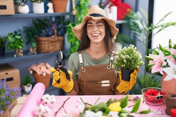 Young brunette woman working at florist shop winking looking at the camera with sexy expression,...