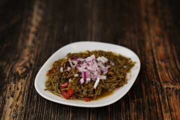 Cut onion on sea beans salad. Traditional aegean appertize. Vegetarian natural food. A plate of sea beans. Turkish and Greek traditional appetizers.