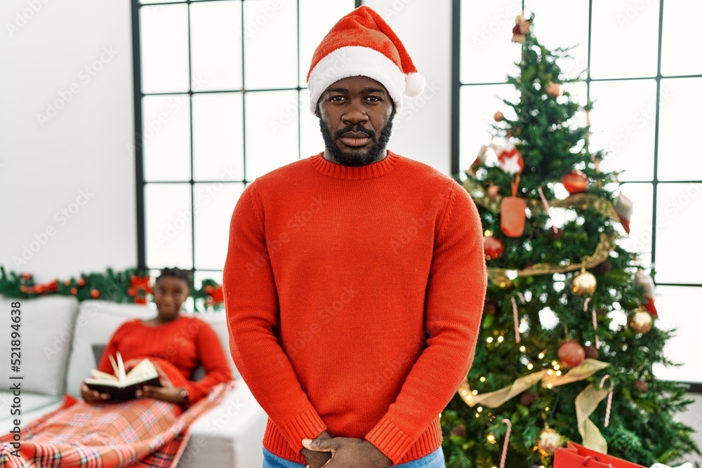 Canvas Prints Young african american man standing by christmas tree skeptic and nervous, frowning upset because of problem. negative person.