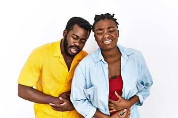 Young african american couple wearing casual clothes with hand on stomach because nausea, painful disease feeling unwell. ache concept.