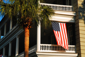 Fototapeta premium American Flag Hangs from a Balcony, of an Antebellum manor in Charleston SC