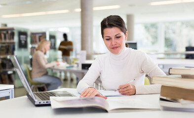 Fototapeta premium Successful woman studying in the library. High quality photo