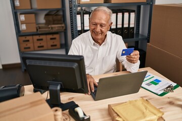 Senior man ecommerce business worker using laptop and credit card at office