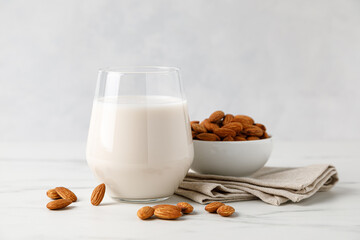Almond milk in a glass and almond nuts - obrazy, fototapety, plakaty