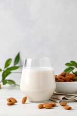 Obraz na płótnie Canvas Almond milk in a glass and almond nuts