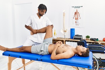 Two men physiptherapist and patient having rehab session stretching leg at clinic
