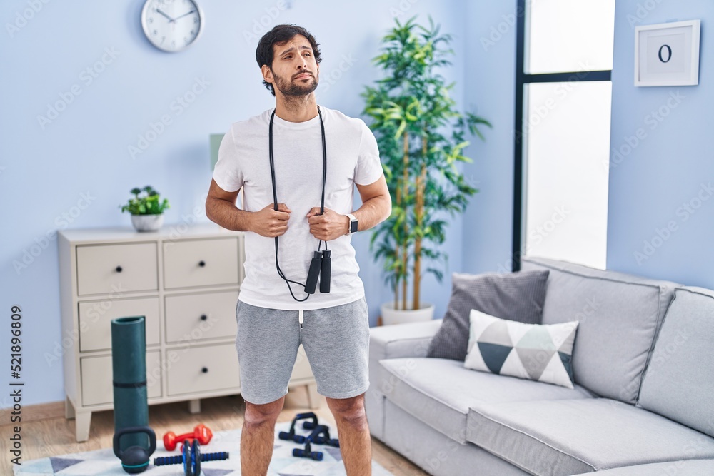 Canvas Prints Handsome latin man wearing sportswear at home smiling looking to the side and staring away thinking.