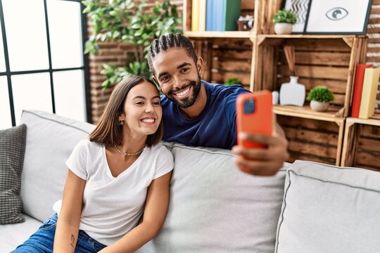 Man and woman couple smiling confident make selfie by the smartphone at home