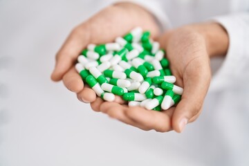 Young arab man pharmacist holding capsules at pharmacy