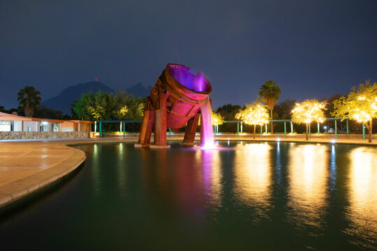 Paseo de Santa Lucia riverwalk Fuente del Crisol at Parque Fundidora Park at Night with Cerro de la Silla at the background, Monterrey, Nuevo Leon, Mexico