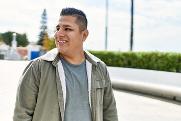 Young latin man smiling happy standing at the city.