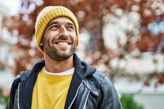 Handsome hispanic man with beard smiling happy outdoors