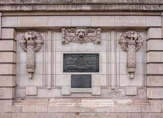 Obraz premium London, Great Britain - July 3, 2022: Beige stone with black information plaque in front of Baker Street subway station features weaponized emblems and lion face, on A501.