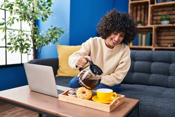 Fototapeta na wymiar Young middle east woman using laptop having breakfast at home