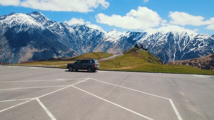 car on the parking near Gergeti Trinity Church, Kazbegi, Georgia. High quality photo