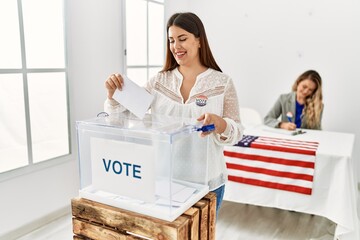 Young american voter woman putting party vote in ballot at electoral college.