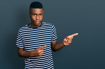 Young african american man pointing with fingers to the side depressed and worry for distress,...