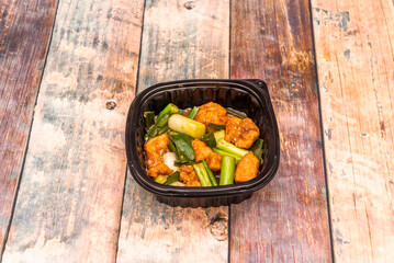 Orange chicken is fried and then sautéed in a slightly sweet soy sauce flavored with chopped dried orange peel. It is often garnished with vegetables, such as bok choy and baby carrots.