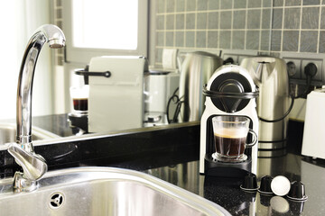 Kitchen of a small apartment with natural gas stoves, wooden countertops and access to a toilet with cabinet and mirror
