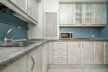 open kitchen with gray wooden cabinets, dressers, cupboards, stainless steel sink and microwave oven