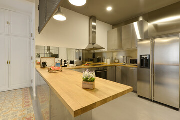 open kitchen with stainless steel cabinets wood countertops with gray floor island and hydraulic tiles