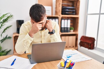 Young hispanic man business worker stressed working at office