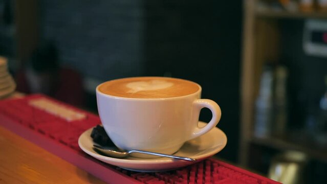 close-up of a female hand in a cafe serves a cup of morning coffee in a bar