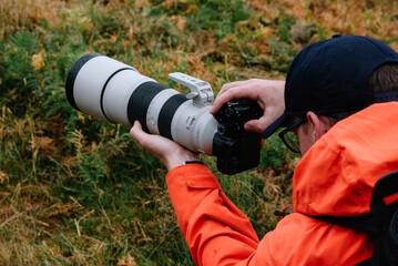 Fototapeta premium Photographer in action with big zoom lens