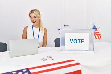 Young caucasian woman at america political campaign election winking looking at the camera with...