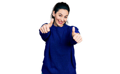 Young hispanic woman wearing casual clothes approving doing positive gesture with hand, thumbs up smiling and happy for success. winner gesture.