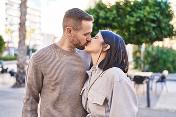 Obraz premium Man and woman couple hugging each other kissing at street