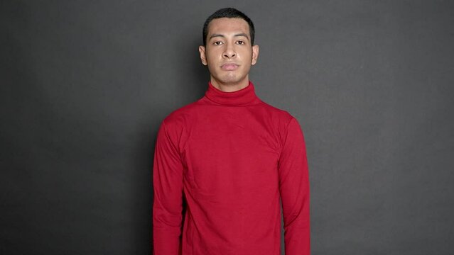 Young man showing his clueless gesture on a black background