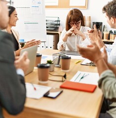 Group of business workers smiling and clapping to partner at the office.