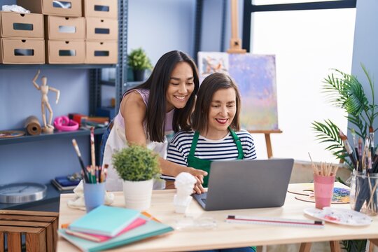 Two women artists using laptop at art studio