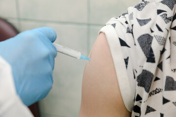 MINSK, BELARUS - 22 July, 2022: doctor vaccinates patient against coronavirus in hospital