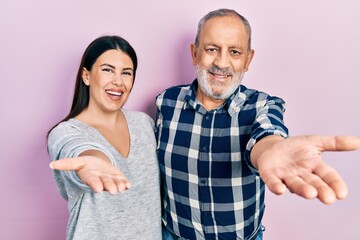 Hispanic father and daughter wearing casual clothes smiling friendly offering handshake as greeting and welcoming. successful business.