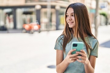 Adorable girl smiling confident using smartphone at street