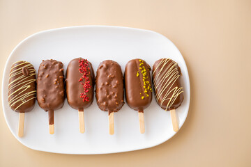  chocolate cupcake ice cream.Chocolate biscuits on a stick in the form of ice cream set on a beige background.Summer desserts.