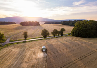 Obraz premium Wheat field with combine croping grain. Agriculture industry harvest background