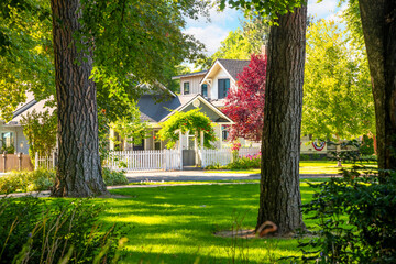 View of a treelined street of historic Fort Grounds homes from the public city park along the lake at Coeur d'Alene, Idaho USA. - obrazy, fototapety, plakaty