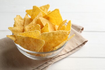 Tortilla chips (nachos) in bowl on white wooden table, closeup