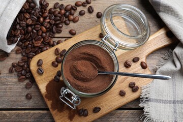 Glass jar of instant coffee and spoon on wooden table, flat lay