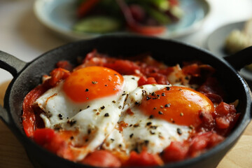 Tasty Shakshouka served in pan on table, closeup
