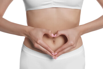 Woman in underwear making heart with hands on her belly near white background, closeup. Healthy...