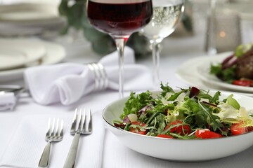 Delicious salad and wine served on table in restaurant