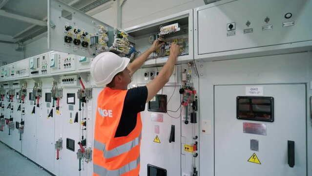 Electrical engineer working check the electric current voltage and overload at front of load center cabinet or consumer unit for maintenance in main power distribution system room.