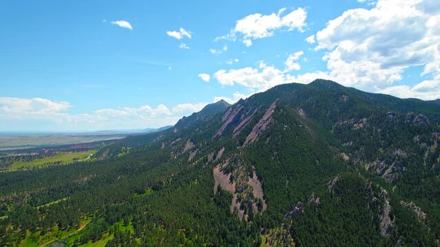 Boulder Flatirons. HD Aerial Drone View Of Famous Green Mountain Rock Formation Recreational Landmark In Western United States Covered In Forest Trees During Beautiful Summer Day.