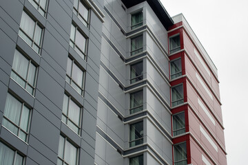 The exterior wall of a contemporary commercial style building with aluminum metal composite panels and glass windows. The futuristic building has engineered diagonal cladding steel frame panels.  