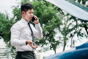 Asian businessman broken car engine breakdown his use mobile calling insurance smartphone problem, Accident emergency on the road concept.